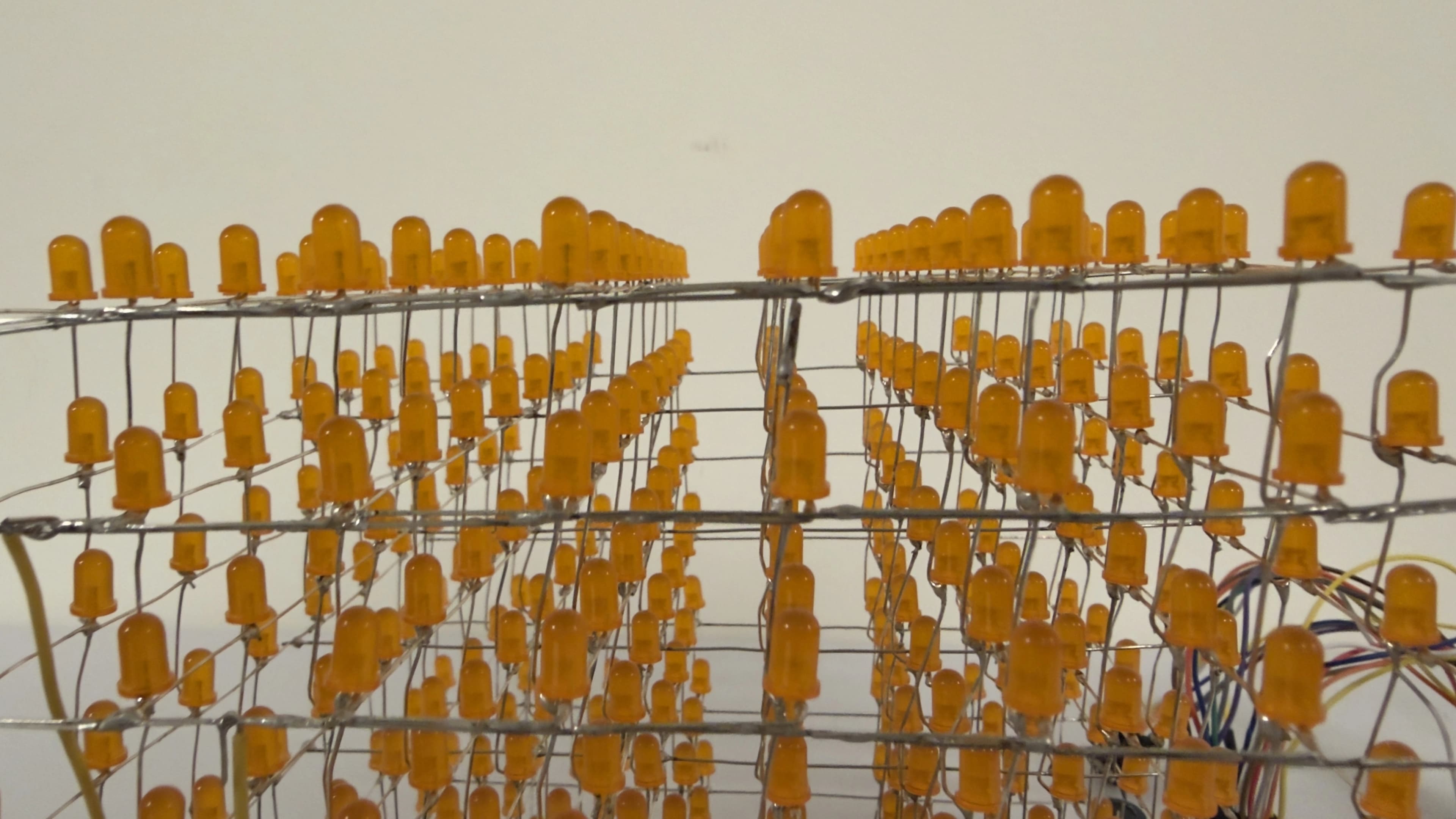 Close-up of the unlit cube's orange LEDs, showing the vertical column wires that act as shared grounds and structural supports