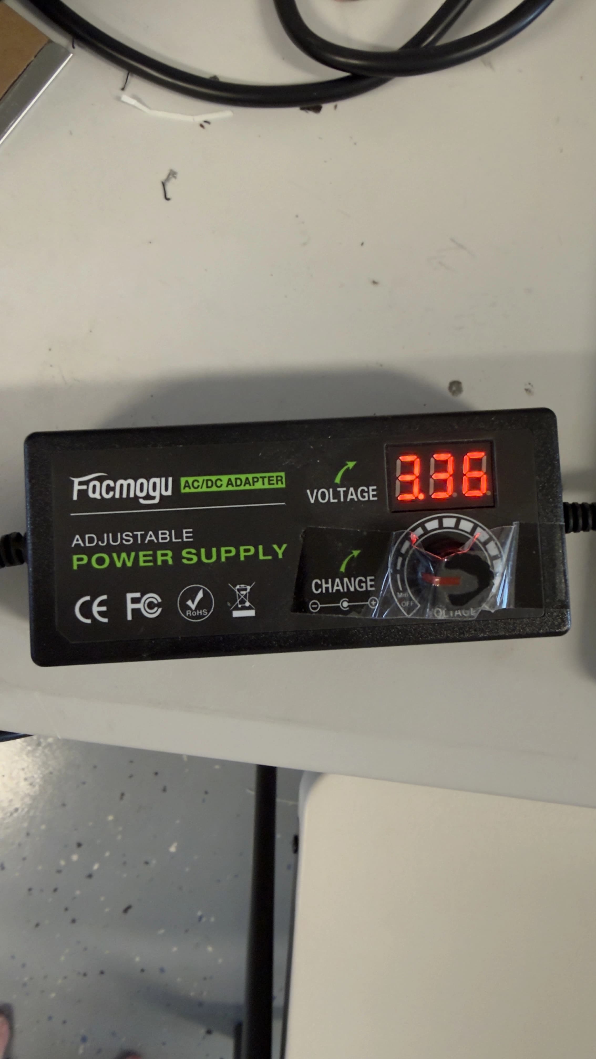 Adjustable AC/DC power supply with its voltage knob and a red seven-segment display reading 3.36 volts