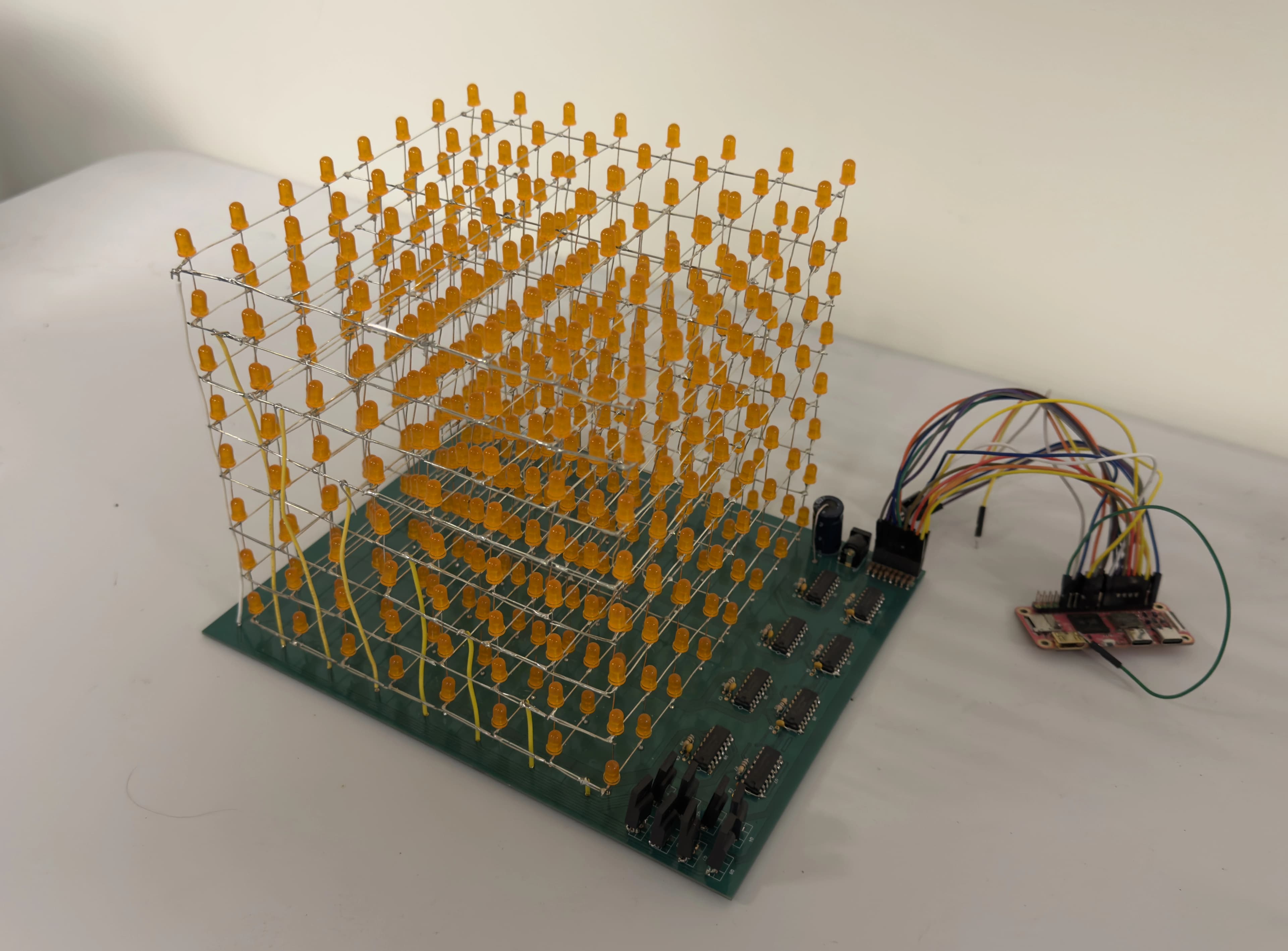 The LED cube, composed of a green PCB and orange LEDs